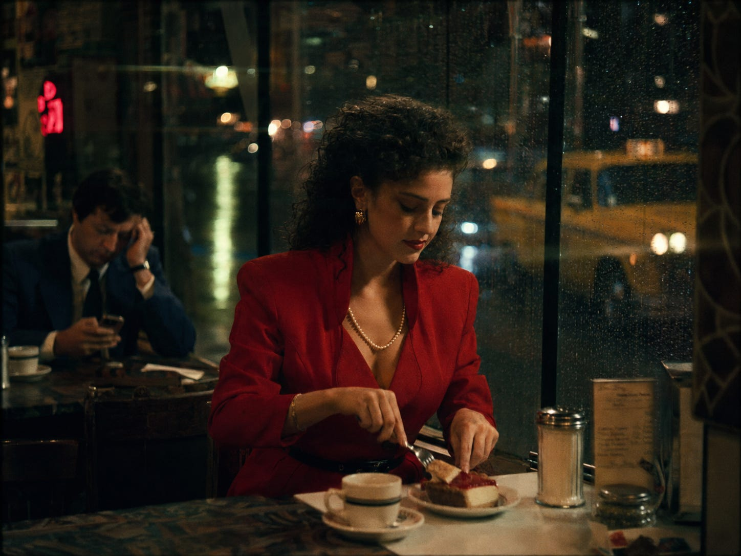 Generated cinematic 1986 New York cafe scene with rainy windows, warm diner light, a woman in red eating pie, a tired man nearby, and a yellow cab outside.