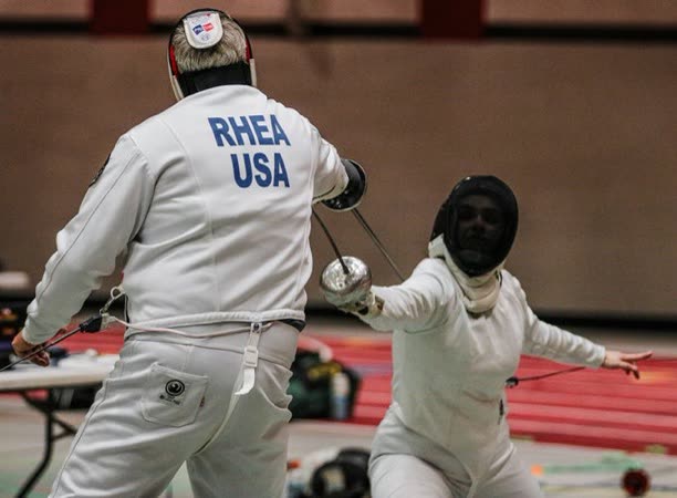 Eric Rhea, RHEA USA on his jacket, engaging blades with an opponent in an épée bout