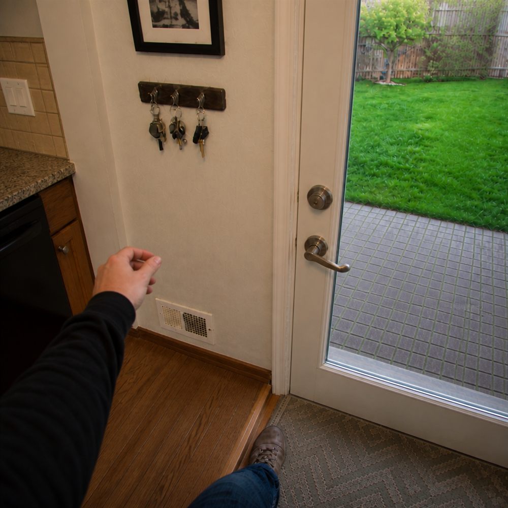 Generated image of John near a kitchen back door and key rack.